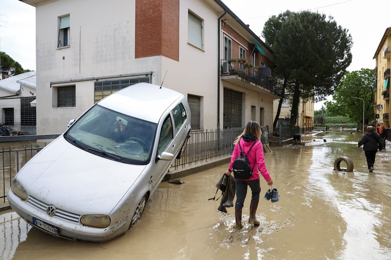 People wade through muddy water  in Faenza, after heavy rain in Italy's Emilia Romagna region. Reuters