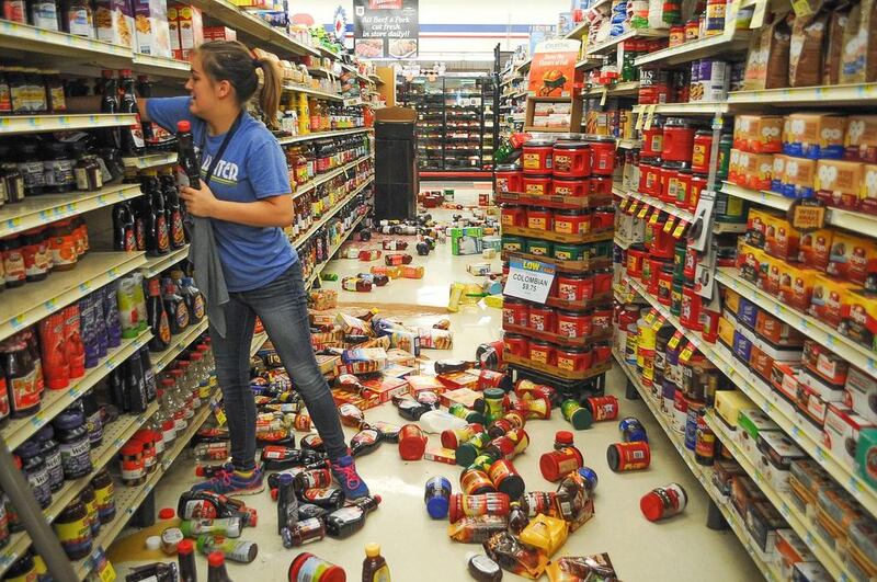 Store employee Talia Pershall, 16, places bottles of syrup back on a shelf while cleaning up at White’s Foodliner grocery store in Pawnee, Oklahoma following a 5.6 magnitude morning earthquake in north-central Oklahoma. The trembler in the edge of the state’s key energy-producing areas rattled the Midwest from Nebraska to North Texas. David Bitton / The News Press via AP