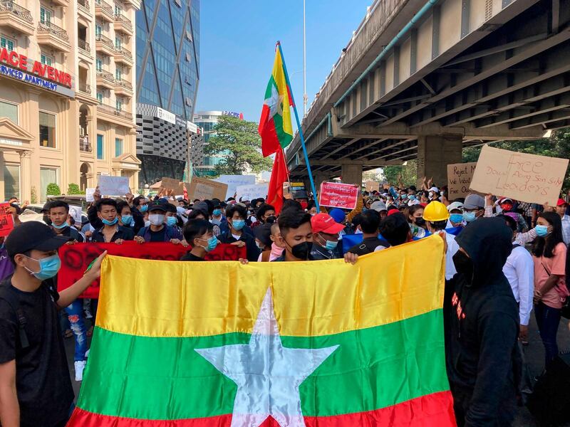 Protesters hold the Myanmar flag as they gather in Yangon, Myanmar. AP