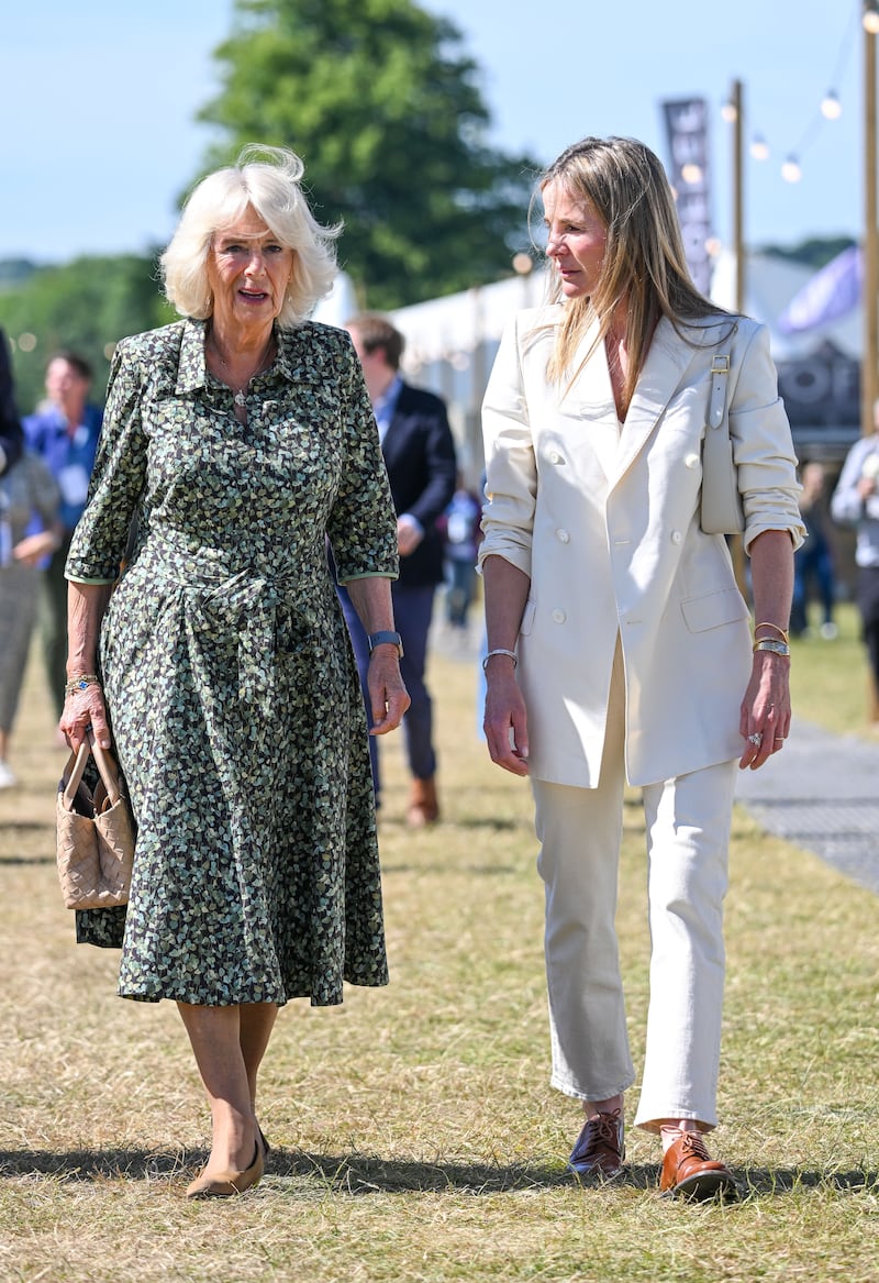 The queen consort, wearing a green floral Fiona Clare dress, walks with Lady Rothermere at the Daily Mail Chalke Valley History Festival on June 20, 2022. Getty Images 