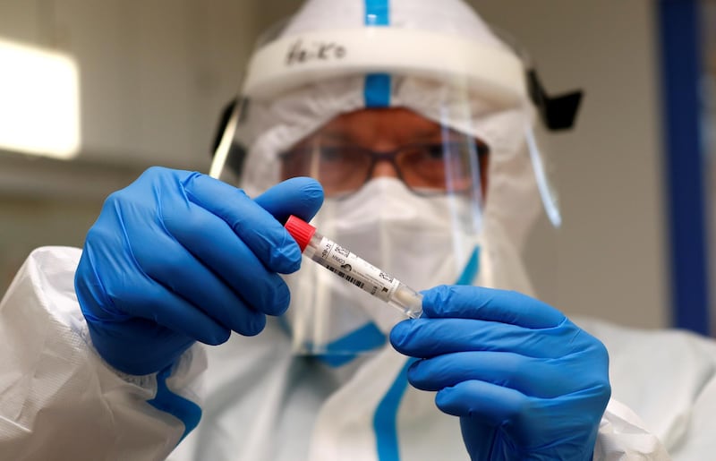 A German Red Cross medical staff holds a smear-test stick of a traveller who returned from the Ukraine, after a voluntary coronavirus test at the new testing centre at the central bus station in Berlin, Germany. Reuters