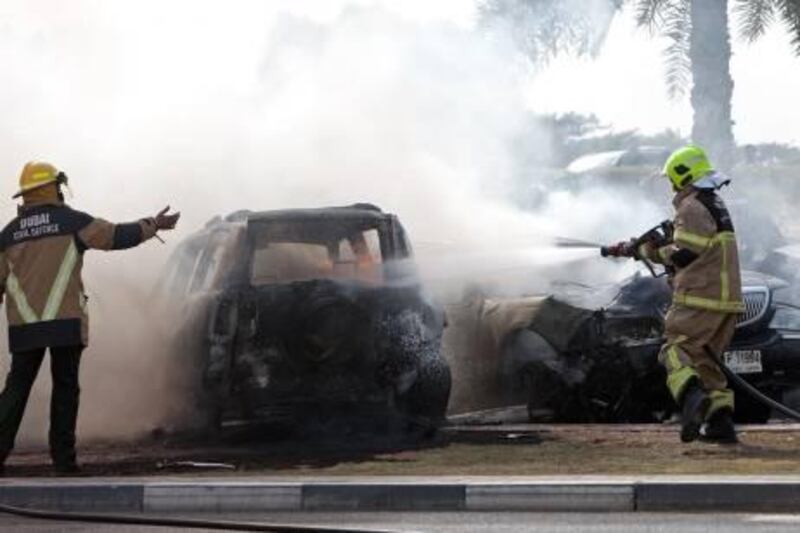 Dubai - August 4, 2010 - Dubai firefighters extinguish a fire resulting from a five car accident on Al Soufah Road near Knowledge Village in Dubai, August 4, 2010. Police reported a four wheel drive vehicle that was speeding had a tire blow out which caused the accident. (Photo by Jeff Topping/The National) 
 