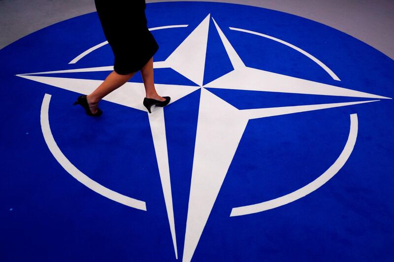 A woman walks across a carpet with the Nato logo at its new headquarters in Brussels. AFP