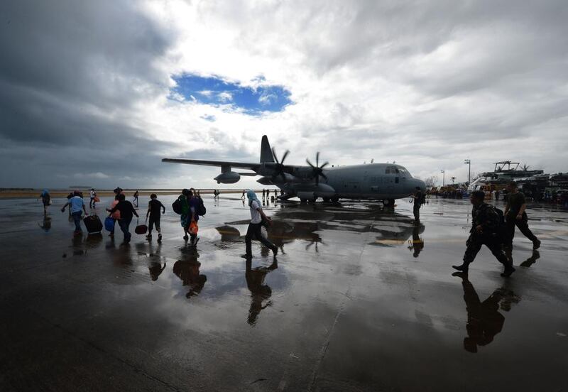 Typhoon survivors run to board a US military evacuation flight from Tacloban airport. Mark Ralston / AFP



