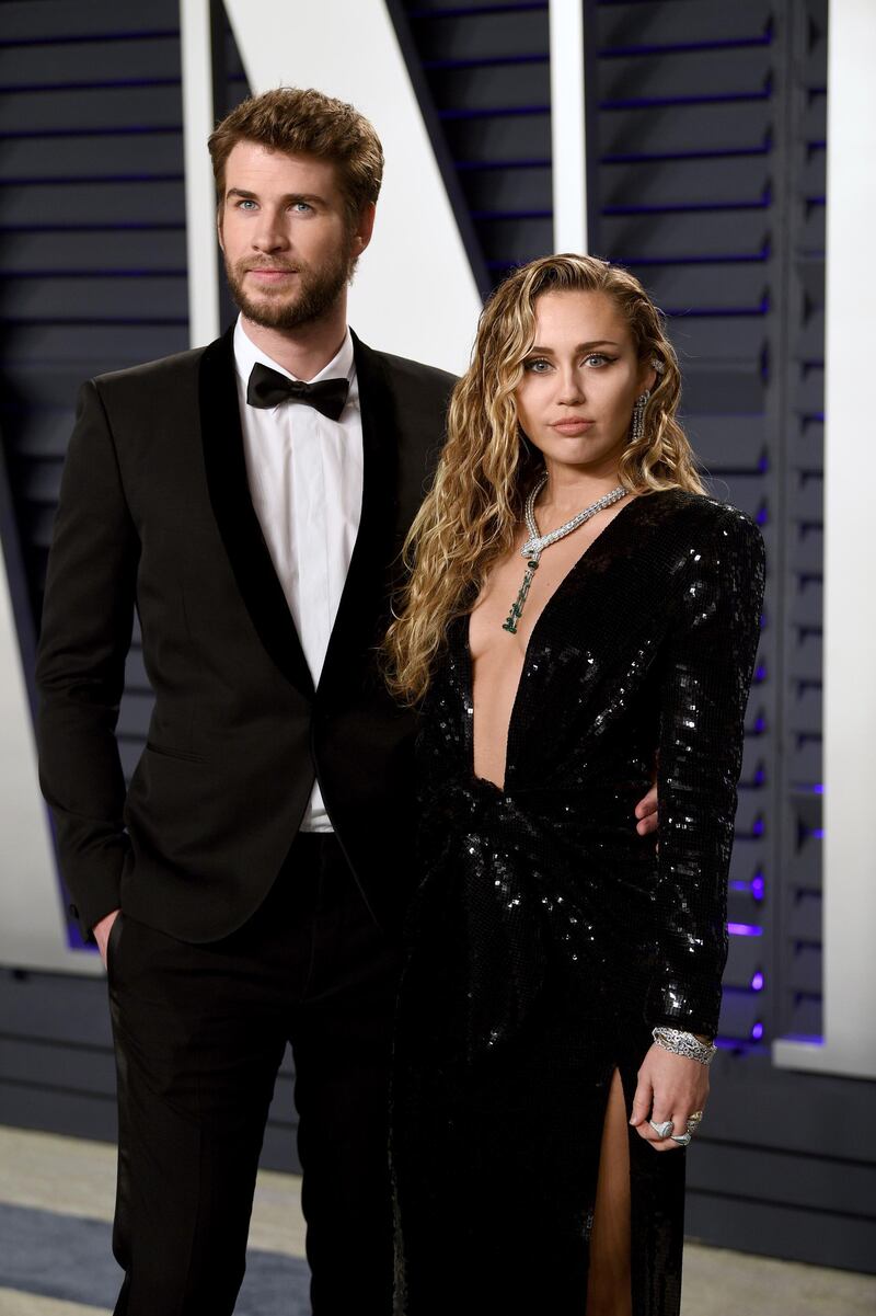 Liam Hemsworth and Miley Cyrus in Saint Laurent arrive at the 2019 Vanity Fair Oscar Party. AP