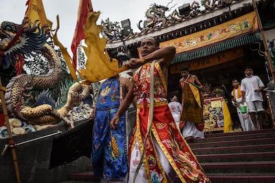 Devotees of the Nine Emperor Gods leave a Chinese shrine in a trance during the annual Phuket Vegetarian Festival in the southern province of Phuket on October 3, 2016.
Southern Thailand's gruesome vegetarian festival got under way on October 2 and devotees throughout the week will show their religious devotion through ritualistic self-mutilation and pain trials, including running over hot coals and piercing their bodies with an astonishing -- and stomach-turning -- variety of objects.  / AFP PHOTO / LILLIAN SUWANRUMPHA