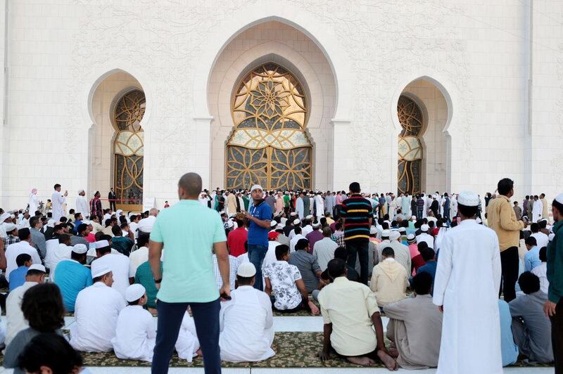 Men wait for the start of Eid prayers. Christopher Pike / The National