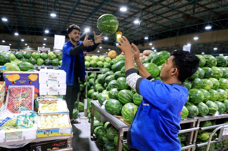 Workers arrange fruit at a fresh produce market in Dubai before the Muslim fasting month. AFP