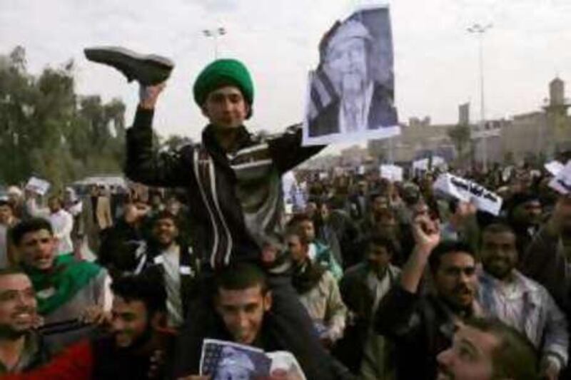 A man beats with a shoe a poster of George W Bush during a protest in Najaf yesterday.