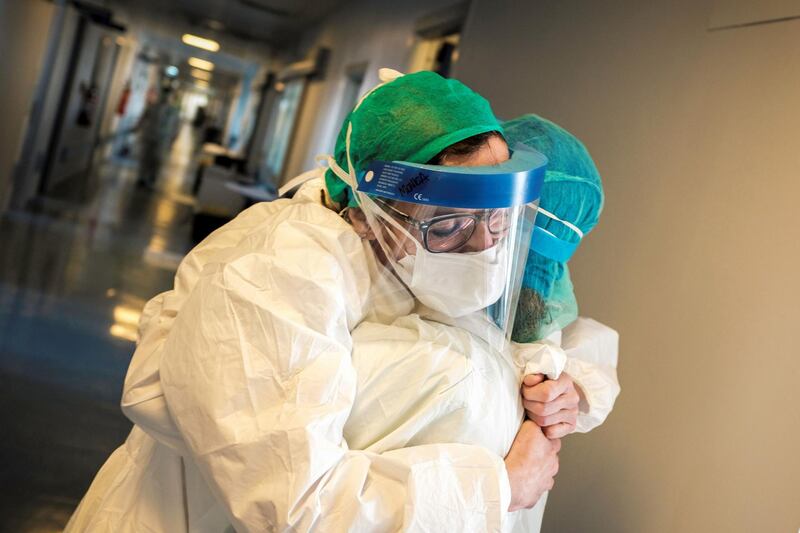 Nurses wearing protective mask and gear embrac at the Cremona hospital, southeast of Milan, Lombardy,  during the country's lockdown aimed at stopping the spread of the COVID-19. AFP