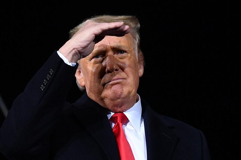 TOPSHOT - US President Donald Trump looks on during a rally in support of Republican incumbent senators Kelly Loeffler and David Perdue ahead of a Senate runoff in Dalton, Georgia on January 4, 2021. President Donald Trump, still seeking ways to reverse his election defeat, and President-elect Joe Biden converge on Georgia on Monday for dueling rallies on the eve of runoff votes that will decide control of the US Senate. Trump, a day after the release of a bombshell recording in which he pressures Georgia officials to overturn his November 3 election loss in the southern state, is to hold a rally in the northwest city of Dalton in support of Republican incumbent senators Kelly Loeffler and David Perdue.  / AFP / MANDEL NGAN
