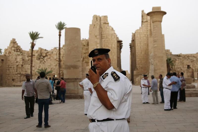 Egyptian security officials stand guard as tourists visit the ruins of the Karnak Temple in Luxor. A suicide bomber blew himself up on Wednesday just steps away from the ancient Egyptian temple. Hassan Ammar / AP Photo