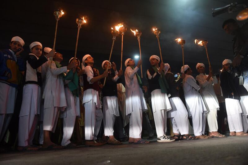 Pakistani religious students hold torches during a rally as part of festivities ahead of Eid-e-Milad-un-Nabi, the birthday of Prophet Mohammad, in Lahore. AFP