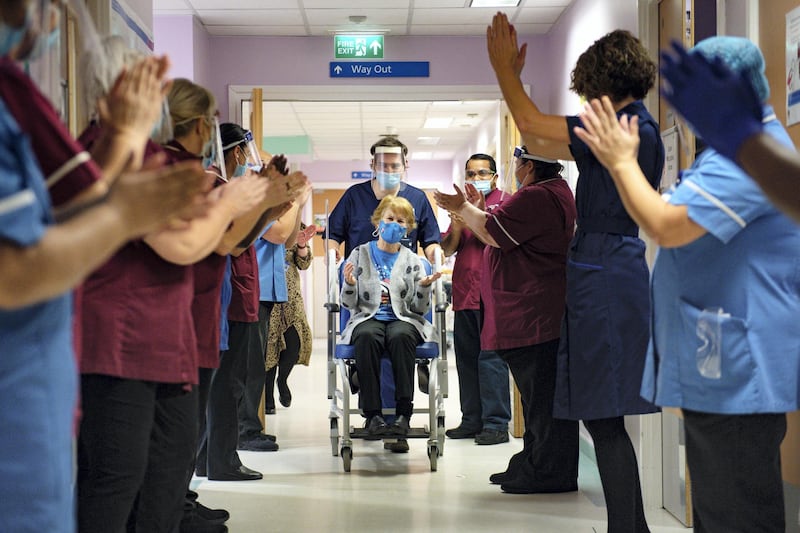 COVENTRY, ENGLAND - DECEMBER 08: Margaret Keenan, 90, is applauded by staff as she returns to her ward after becoming the first person in the United Kingdom to receive the Pfizer/BioNtech covid-19 vaccine at University Hospital at the start of the largest ever immunisation programme in the UK's history on December 8, 2020 in Coventry, United Kingdom. More than 50 hospitals across England were designated as covid-19 vaccine hubs, the first stage of what will be a lengthy vaccination campaign. NHS staff, over-80s, and care home residents will be among the first to receive the Pfizer/BioNTech vaccine, which recently received emergency approval from the country's health authorities. (Photo by Jacob King - Pool / Getty Images)