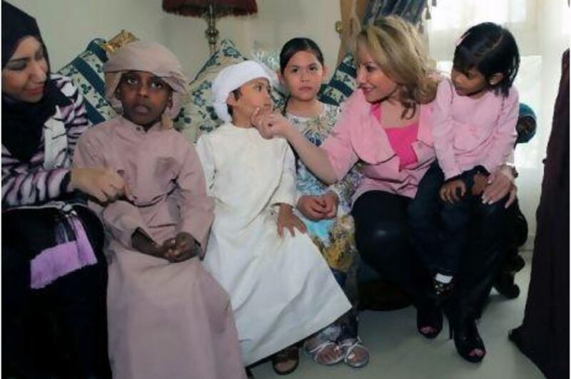 The Kuwaiti actress Huda Hussain, right, speaks with Saif Mohammed at an orphanage run by the Dar Zayed Centre for Family Care in Al Ain. Also pictured is Shaimaa al Mulla, left, a friend of Ms Hussain's.