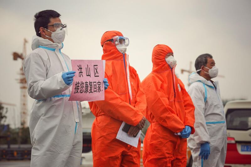 Staff members welcome recovered patients (unseen) as they are discharged from Leishenshan Hospital, the makeshift hospital for the COVID-19 coronavirus patients, in Wuhan in China's central Hubei province.  AFP