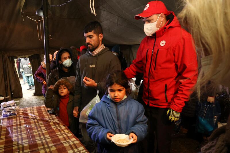Migrants receive food inside a Red Cross tent in Belarus. AP Photo
