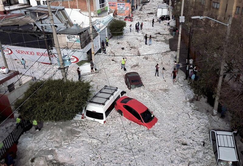 Vehicles buried in hail are seen in the streets in the eastern area of Guadalajara, Mexico. AFP