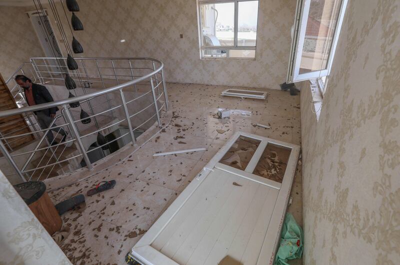 A man inspects the damage at his home.