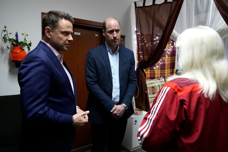 Prince William and Mayor of Warsaw Rafal Trzaskowski talk to a Ukrainian woman at the accommodation centre. AP