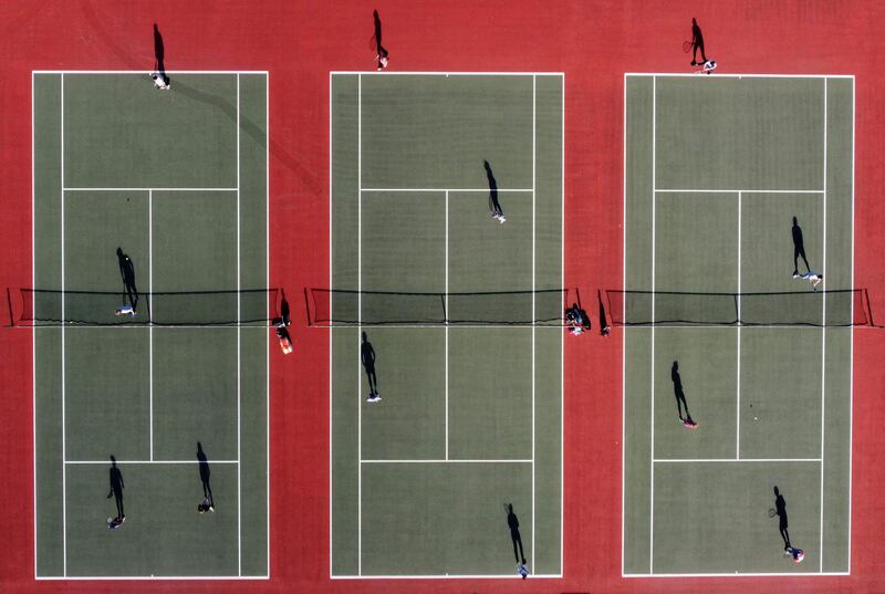 People play tennis at the Mersey Bowmen Lawn Tennis Club in Liverpool, England, as the country's third Covid-19 lockdown restrictions ease, allowing groups of up to six to meet outside. AFP