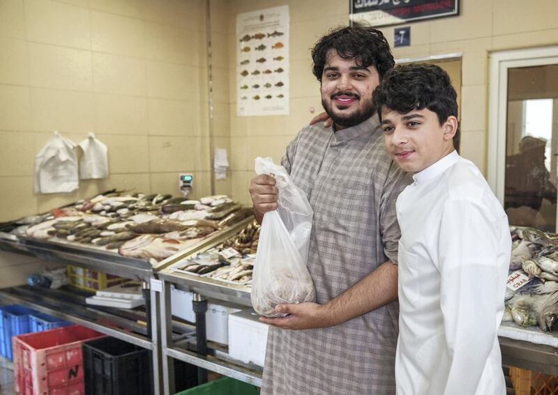 Abu Dhabi, United Arab Emirates, June 27, 2019.   Mirfa (west of ad)  to find out what people think about ghadan.  -- The Mirfa Fish Market.  (L-R)  Omar and Ibrahim buying fish for their mother.
Victor Besa/The National
Section:  NA
Reporter:Anna Zacharias