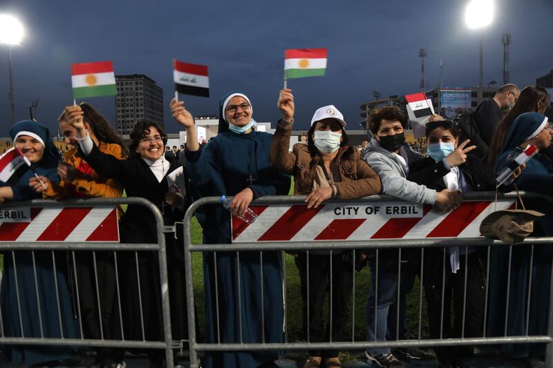 Nuns wave flags of Iraq, Kurdistan, and the Holy See as they wait for the arrival of Pope Francis at the Franso Hariri Stadium in Erbil. AFP