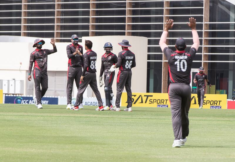 UAE players celebrate taking an Oman wicket during the Cricket World Cup League 2 match at the ICC Academy in Dubai. 