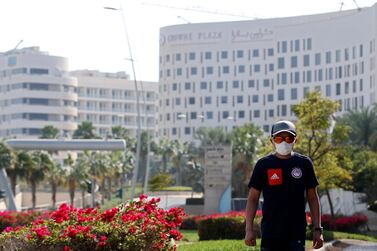 A man wears a face mask walks in front of the Crowne Plaza hotel in Yas Island, Abu Dhabi. EPA