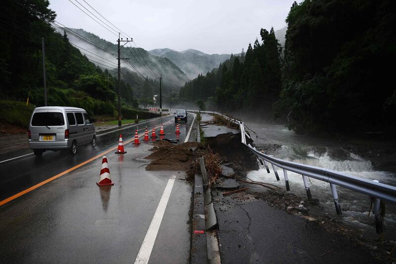 A collapsed road caused by heavy rain is seen in Ono, Kumamoto prefecture on July 7, 2020. Emergency services in western Japan were "racing against time" to rescue people stranded by devastating floods and landslides, with at least 50 feared dead and more torrential rain forecast. / AFP / CHARLY TRIBALLEAU
