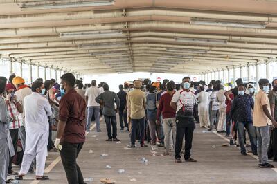 ABU DHABI, UNITED ARAB EMIRATES. 16 APRIL 2020. COVID-19 Testing station in Al Mussafah. Men wait in line for their pre-check ahead of being tested. (Photo: Antonie Robertson/The National) Journalist: Haneen Dajani. Section: National.