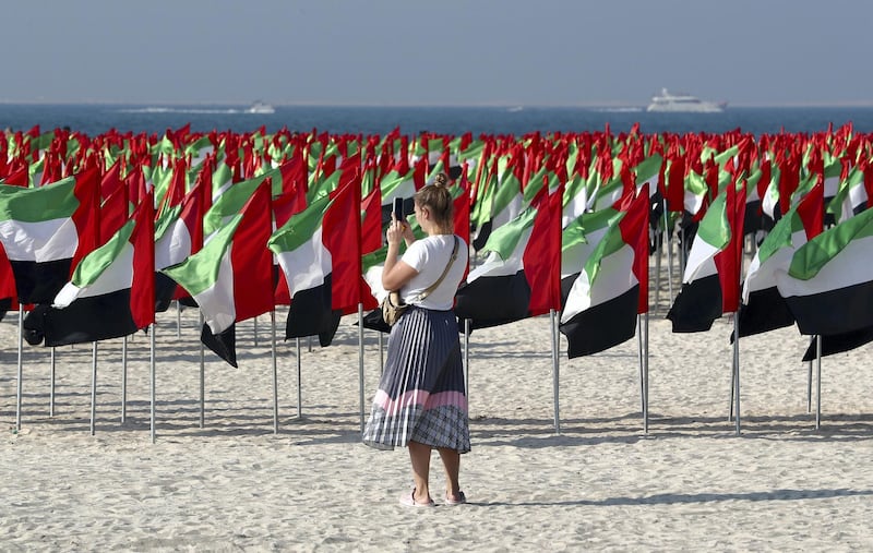 DUBAI, UNITED ARAB EMIRATES , Dec 1 – 2019 :- One of the visitor taking photos of the UAE flag at the Flag Garden near the Kite beach in Dubai. ( Pawan Singh / The National )  For News/Big Picture/Instagram