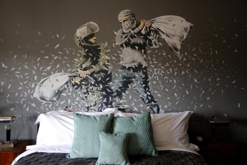 An artwork, depicting an Israeli soldier, left, and a Palestinian protester during a pillow fight, by British street artist Banksy is painted onto a wall in a bedroom of the Walled Off Hotel. Abed Al Hashlamoun / EPA