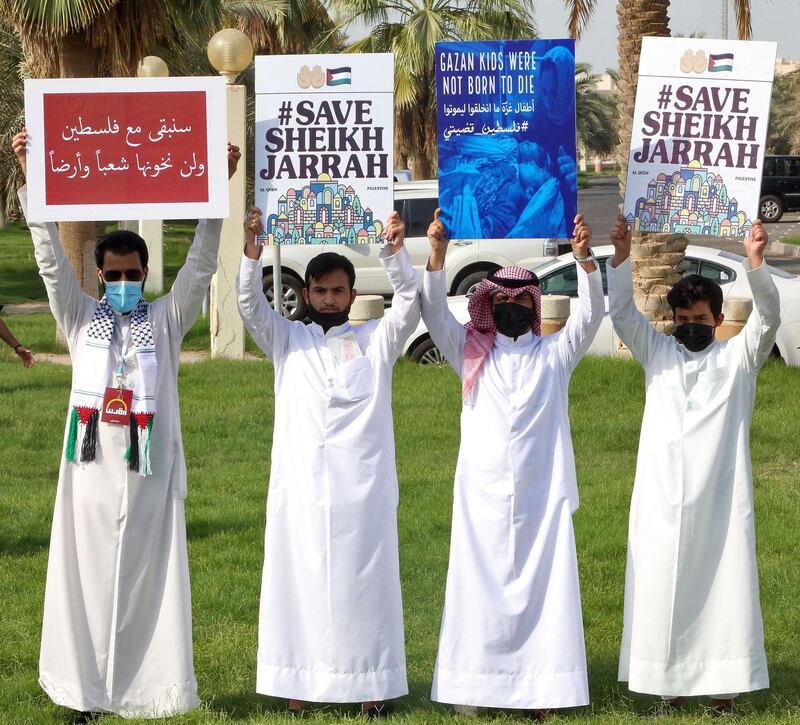 Protesters hold up signs expressing their solidarity with the Palestinian people, in Kuwait City, Kuwait. AFP
