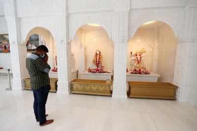 A devotee prays before Hindu deities during the soft launch of the temple last month in Jebel Ali, Dubai. Chris Whiteoak / The National