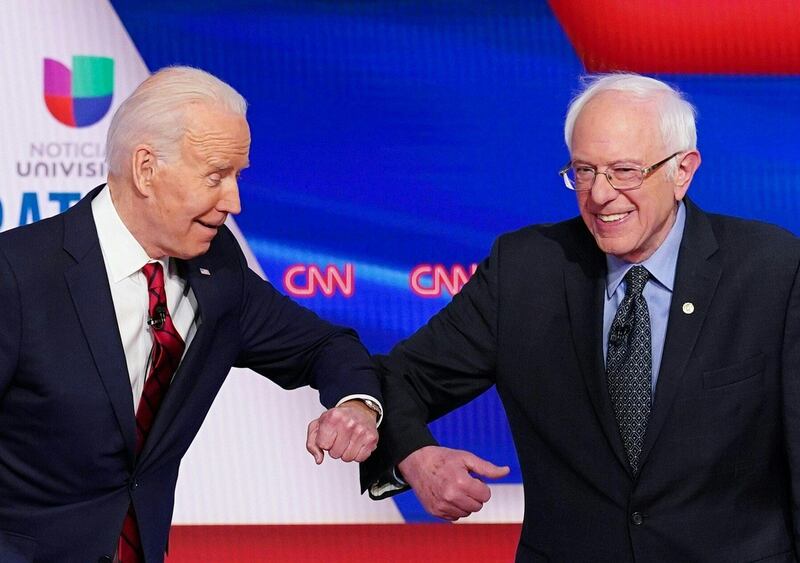 (FILES) In this file photo taken on March 15, 2020 Democratic presidential hopefuls former US vice president Joe Biden (L) and Senator Bernie Sanders (R) greet each other with an elbow bump as they arrive for the 11th Democratic Party 2020 presidential debate in a CNN Washington Bureau studio in Washington, DC. Americans voted March 17, 2020 in Democratic primaries in Florida, Illinois and Arizona in an election day like no other, as the rapidly spreading coronavirus pandemic blighted the US presidential nomination race between frontrunner Joe Biden and Bernie Sanders. - ALTERNATIVE CROP
 / AFP / MANDEL NGAN / ALTERNATIVE CROP
