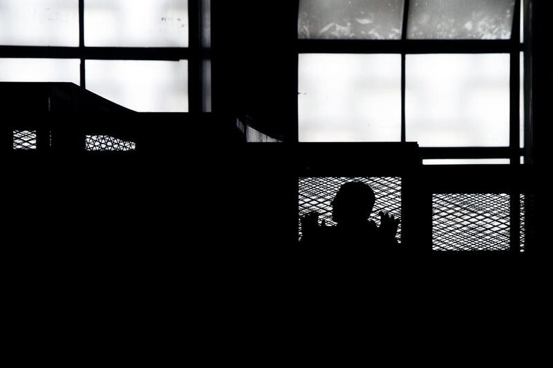 An Al-Jazeera channel’s journalist stands inside the defendants cage with his colleagues during their trial for allegedly supporting the Muslim Brotherhood at Cairo’s Tora prison. Mahmoud Khaled / AFP