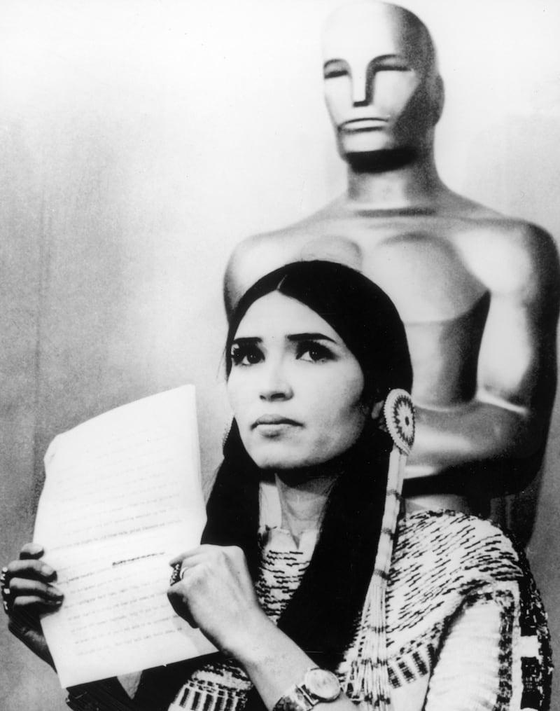 Littlefeather holds a written statement from actor Marlon Brando refusing his Best Actor Oscar on stage at the Academy Awards, Los Angeles, California on March 27, 1973. Getty Images