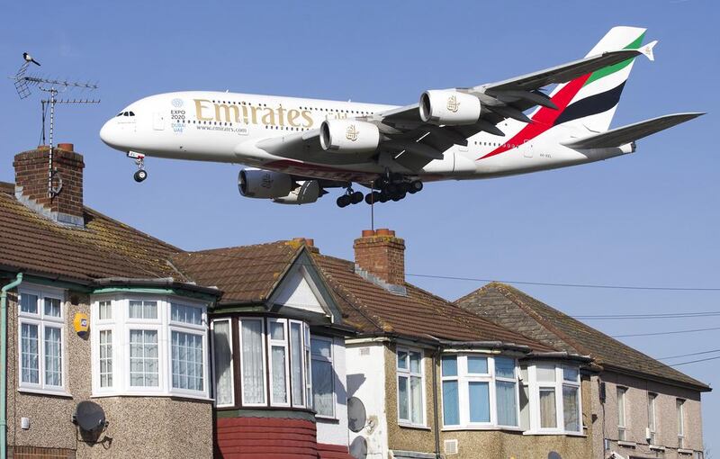 An Emirates Airbus A380 aircraft is seen above roof tops as it comes into land at Heathrow Airport. Justin Tallis / AFP