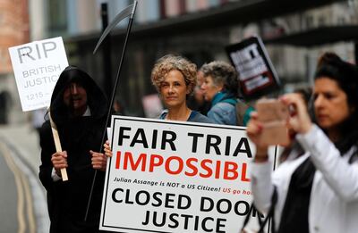 Protesters stand opposite the Central Criminal Court, the Old Bailey, in London, Monday, Sept. 21, 2020, as the Julian Assange extradition hearing to the US continues. (AP Photo/Frank Augstein)