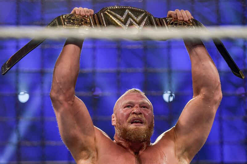Brock Lesnar holds up the championship belt.