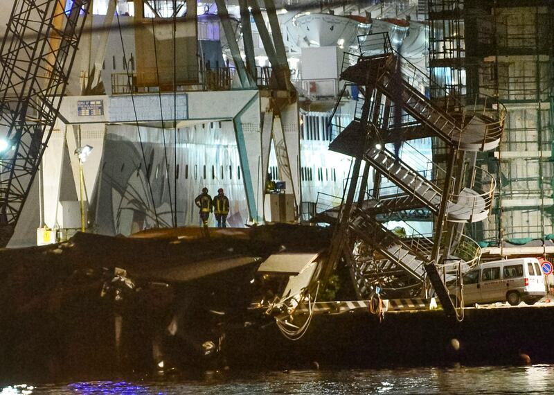 Rescuers search what is left of the toppled control tower of the port of Genoa, northern Italy, after a cargo ship slammed into it killing at least three people, Tuesday, May 7, 2013. A half-dozen people remain unaccounted for early Wednesday, after a cargo ship identified as the Jolly Nero of the Ignazio Messina & C. SpA Italian shipping line, slammed into the port. (AP Photo/Francesco Pecoraro) *** Local Caption ***  Italy Cargo Ship Crash.JPEG-03161.jpg