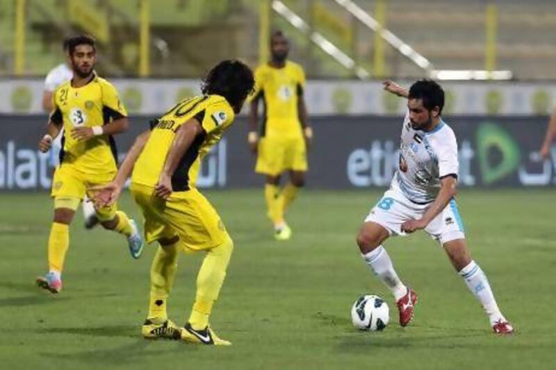 Ahmed Ibrahim of Al Wasl, left, sets to defend his space from Saleh Hamad of Baniyas.