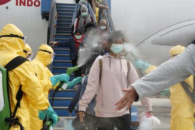 Medical officers spray Indonesian nationals with antiseptic after they arrived from Wuhan, China center of the coronavirus epidemic, before transferring them to the Natuna Islands military base to be quarantined, at Hang Nadim Airport in Batam, Riau Islands, Indonesia, February 2, 2020 in this photo taken by Antara Foto.  Antara Foto/via REUTERS  ATTENTION EDITORS - THIS IMAGE WAS PROVIDED BY A THIRD PARTY. MANDATORY CREDIT. INDONESIA OUT.     TPX IMAGES OF THE DAY