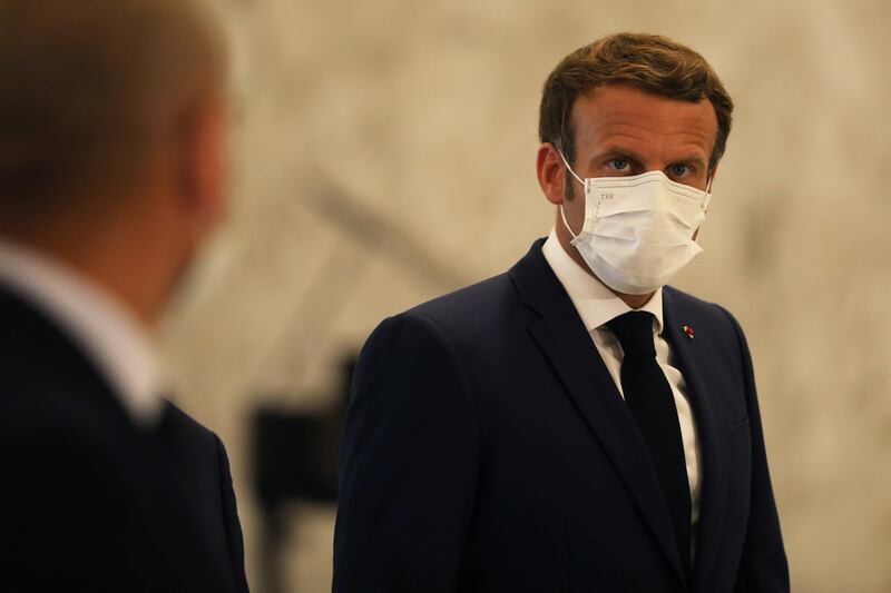French President Emmanuel Macron wears a protective face mask as he meets Lebanon's President Michel Aoun following Tuesday's blast in Beirut's port area, at the presidential palace in Baabda, Lebanon. Reuters