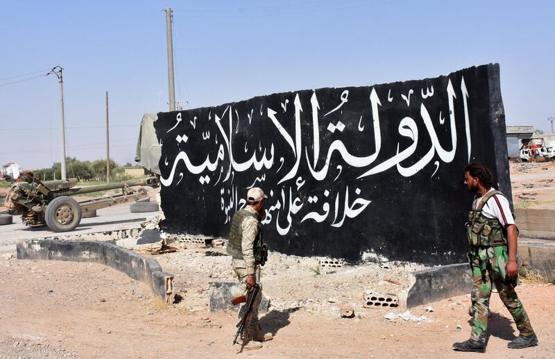 Syrian pro-government forces set up a road checkpoint next to a mural reading the Arabic: "Islamic State" after they took control of the northern Syrian town of Maskanah from the jihadists on June 5, 2017.  / AFP PHOTO / George OURFALIAN