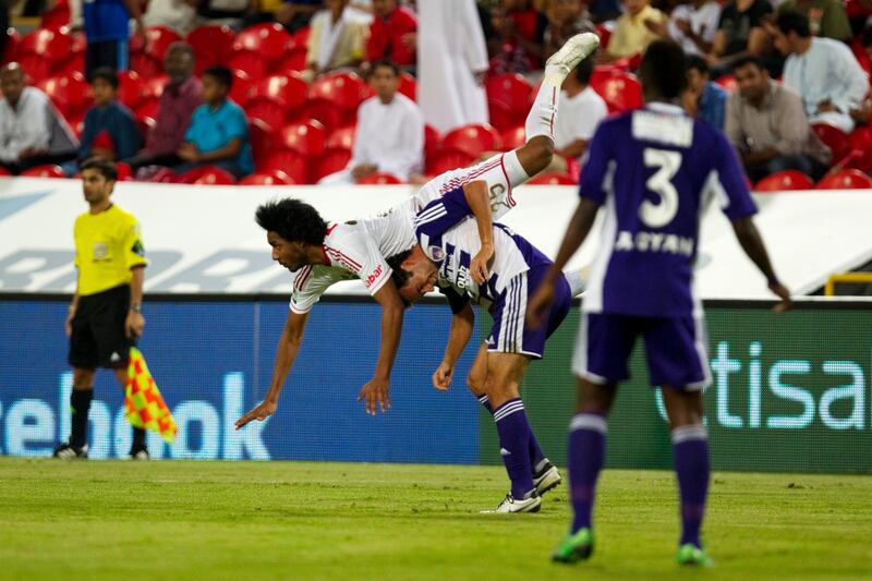 Abu Dhabi, United Arab Emirates, October 29, 2012:   Al Jazira's Khamis Esmail falls over Al Ain's Alex Brosque while jumping for a ball during their Pro League match at Mohammad bin Zayed Stadium in Abu Dhabi on October 29, 2012. Christopher Pike / The National