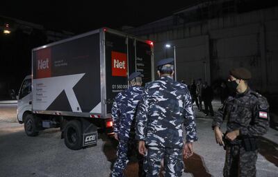 Members of Lebanese security forces stand next to a truck transporting boxes of the first shipment of the COVID-19 Pfizer-BioNTech vaccine upon arrival to the Rafic Hariri University Hospital in the capital Beirut, on February 13, 2021. Lebanon received its first vaccines against the coronavirus, a day before an inoculation drive kicks off in the crisis-hit Mediterranean country. / AFP / ANWAR AMRO
