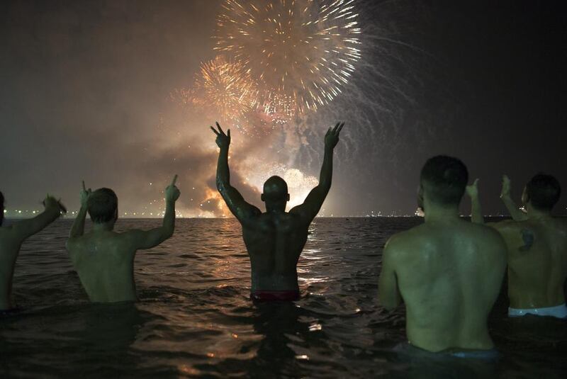 People watch the fireworks exploding over Copacabana beach in Rio de Janeiro. Leo Correa / AP Photo