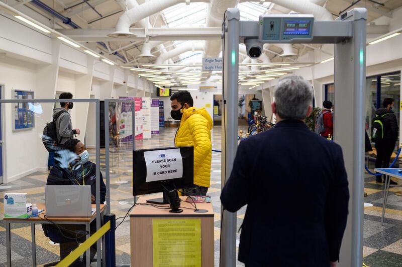 Students and staff have their temperature taken and scan their ID pass at the entrance to a campus building at the University of Bolton, in Bolton. Oli Scarff / AFP